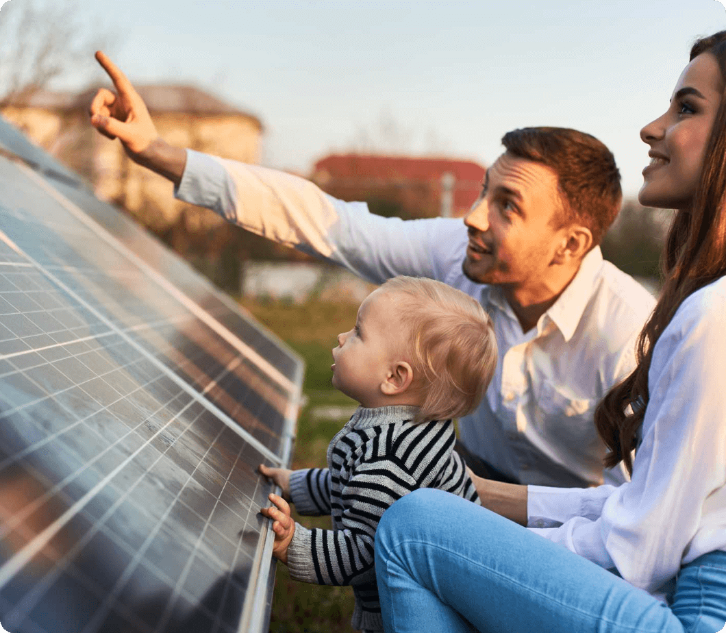 Um casal com seu bebê observando o sol refletindo no painél solar da família